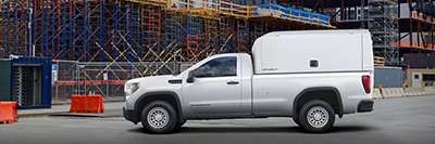 Spacekap's Wild fiberglass service body on a GMC pickup truck in a field city construction site - minimized