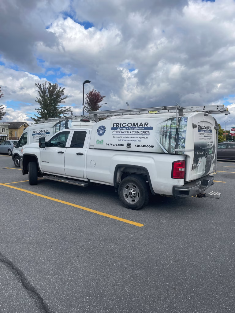White Frigomar service truck parked in a parking lot under a cloudy sky