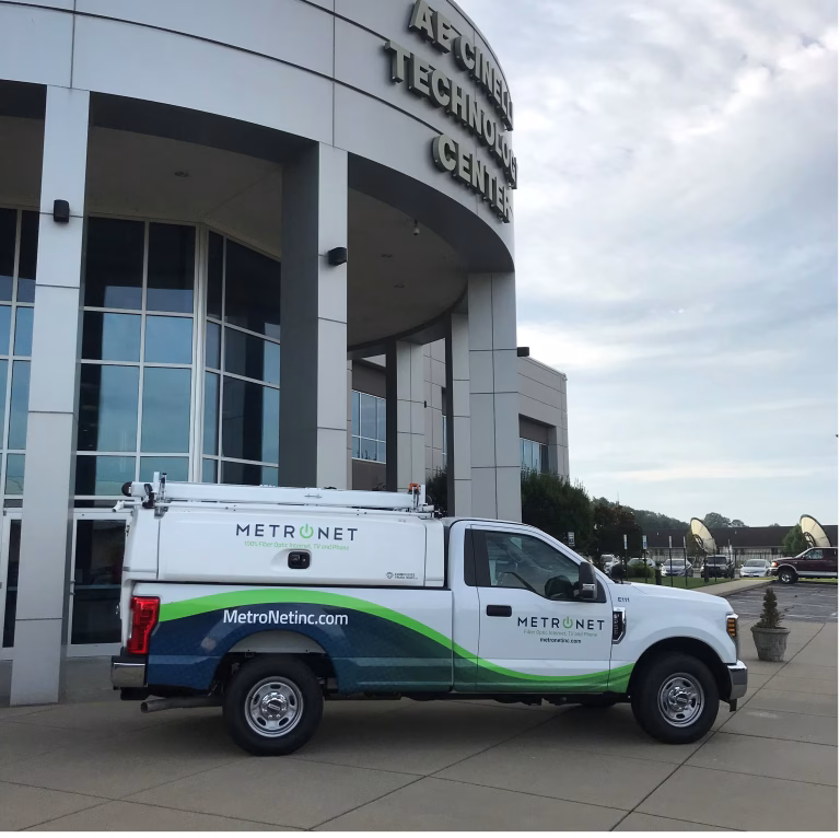 MetroNet service truck parked outside AE Cine Technology Center with a cloudy sky