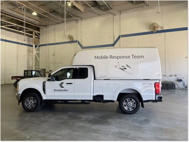 White Bombardier Mobile Response Team truck parked inside a spacious industrial garage